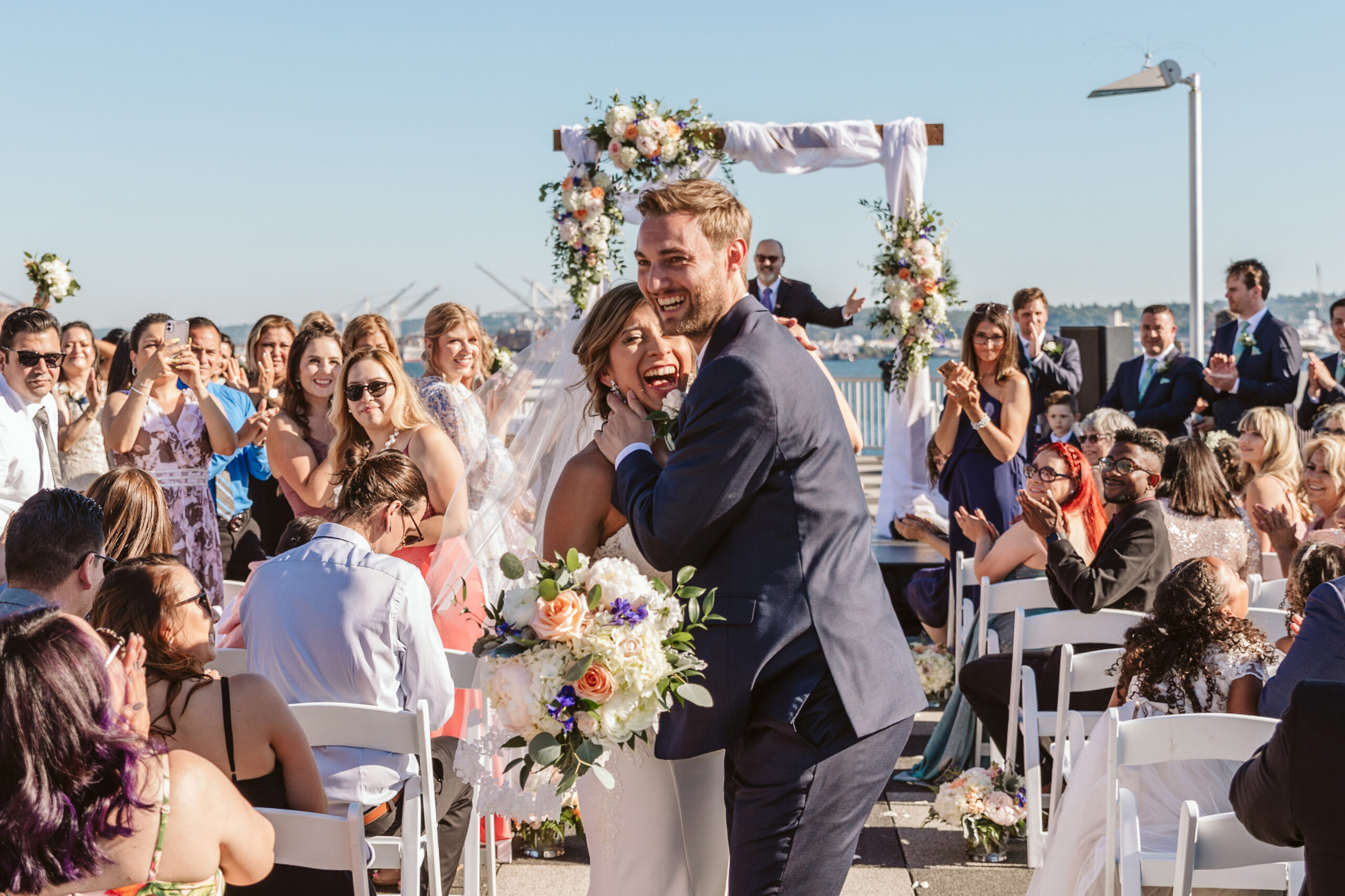 couple kissing in wedding aisle on top of bell harbor int center in wa