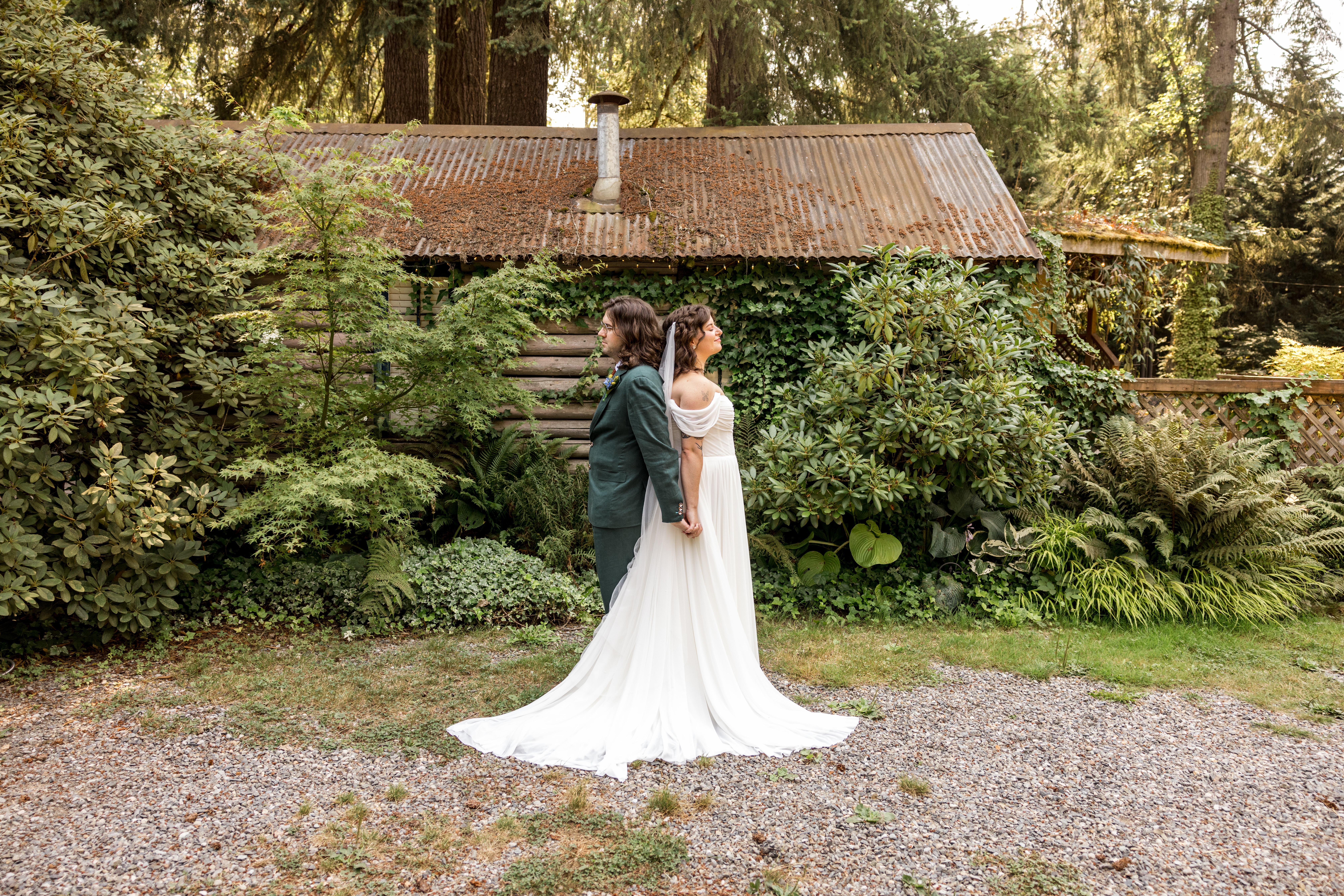 Wedding Couple having a First Touch, standing back to back holding hands waiting until ceremony to see each other.