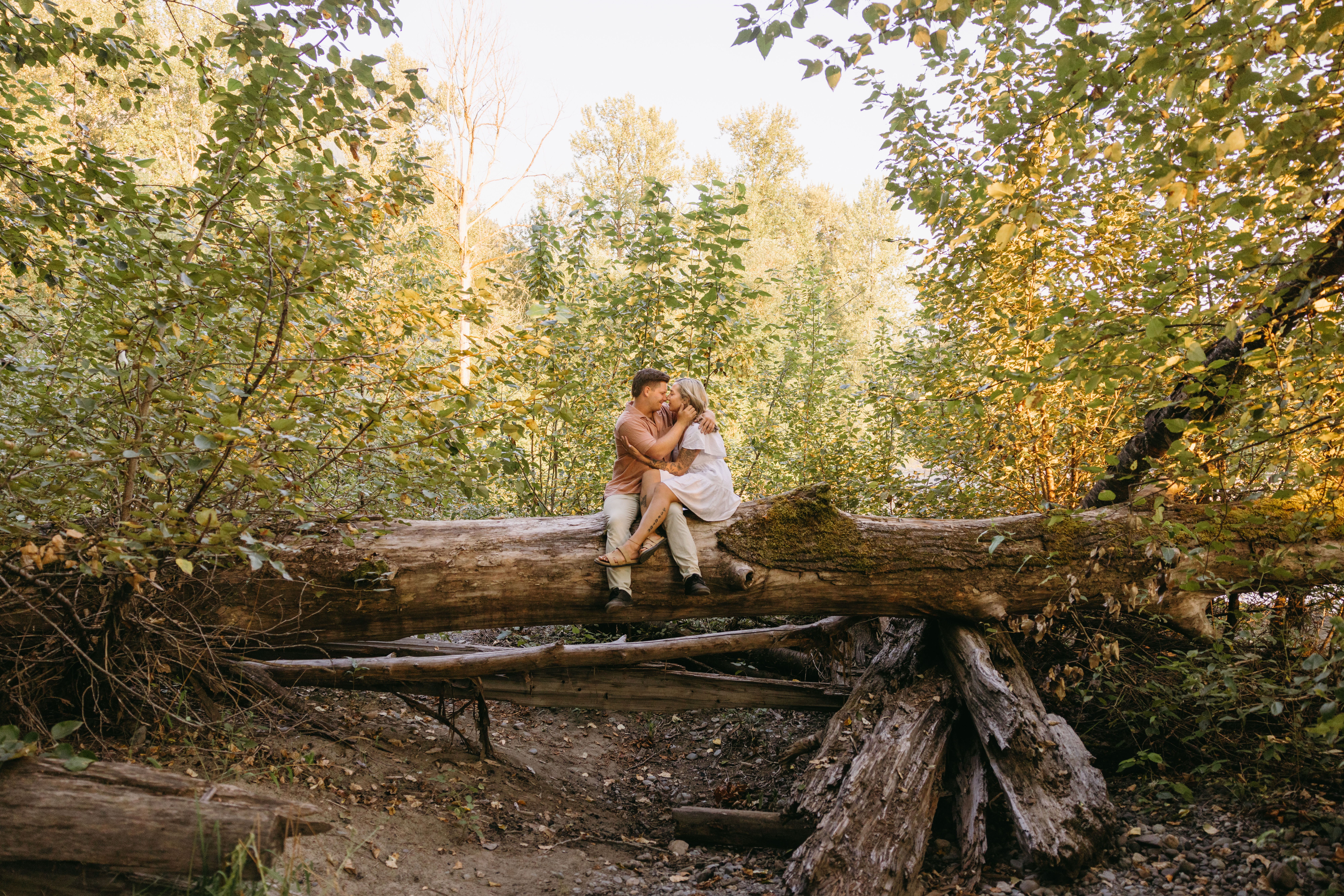 Couple sitting on large log near the river, Snoqualmie North Bend Washington